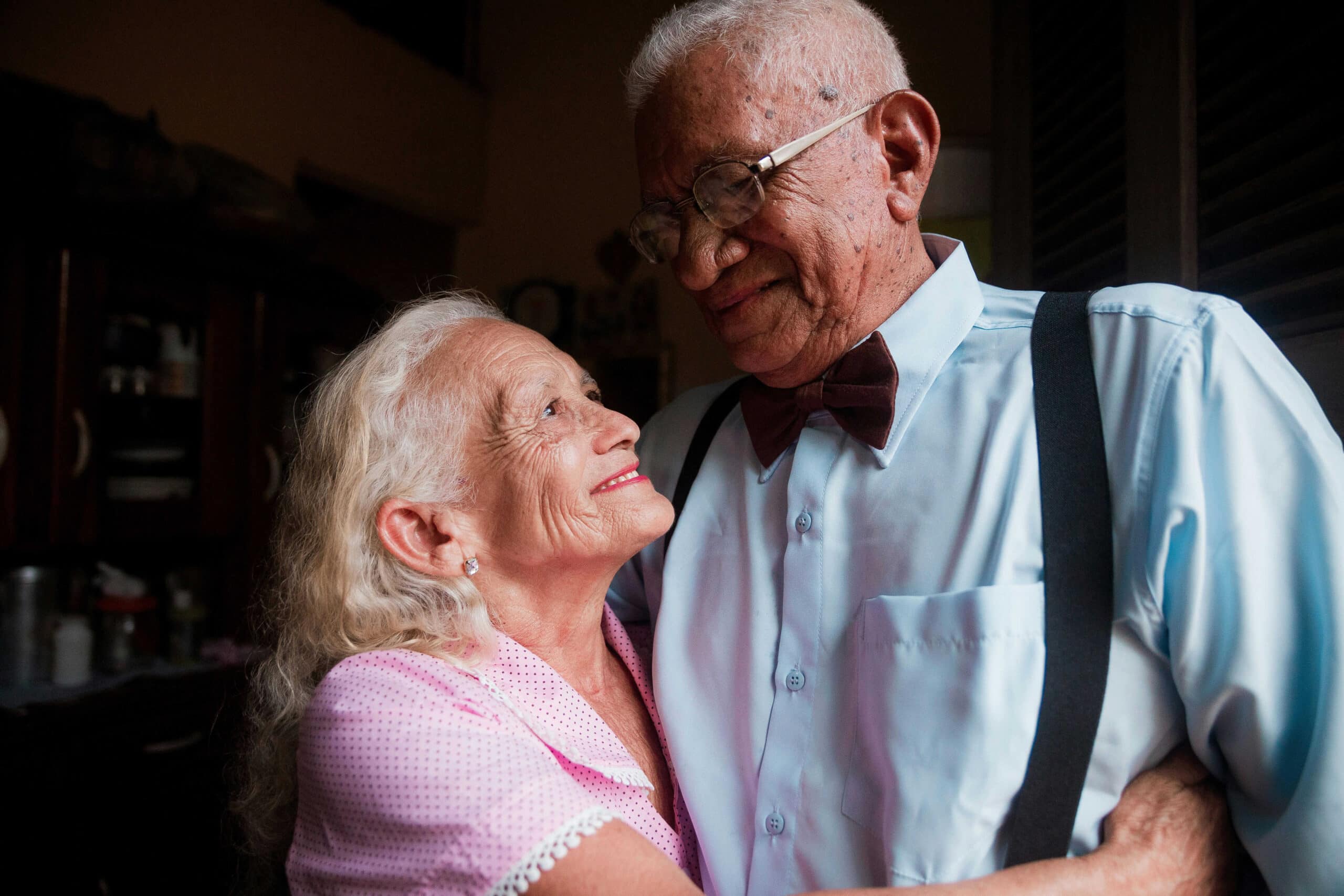 elderly couple embracing and smiling