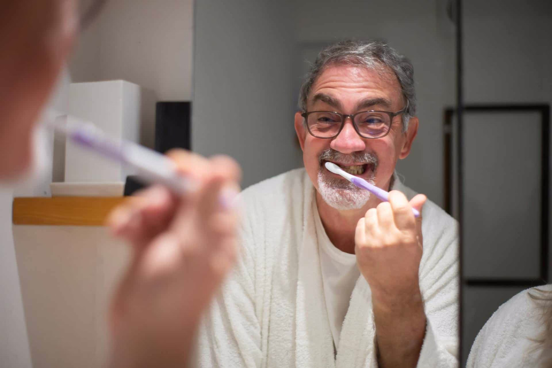 elderly man brushing teeth